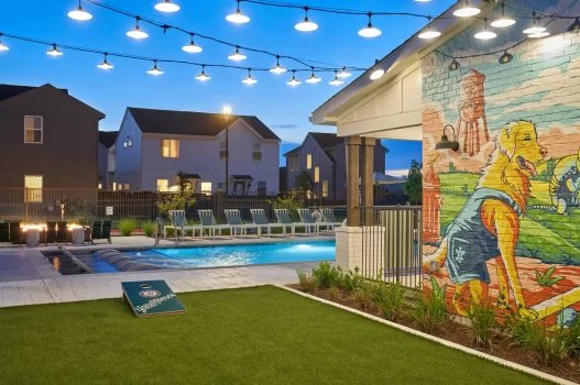 Yardhomes community pool and mural at dusk